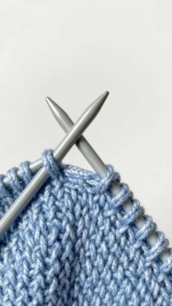Closeup of beginner knit stitch on US size 8 needles
