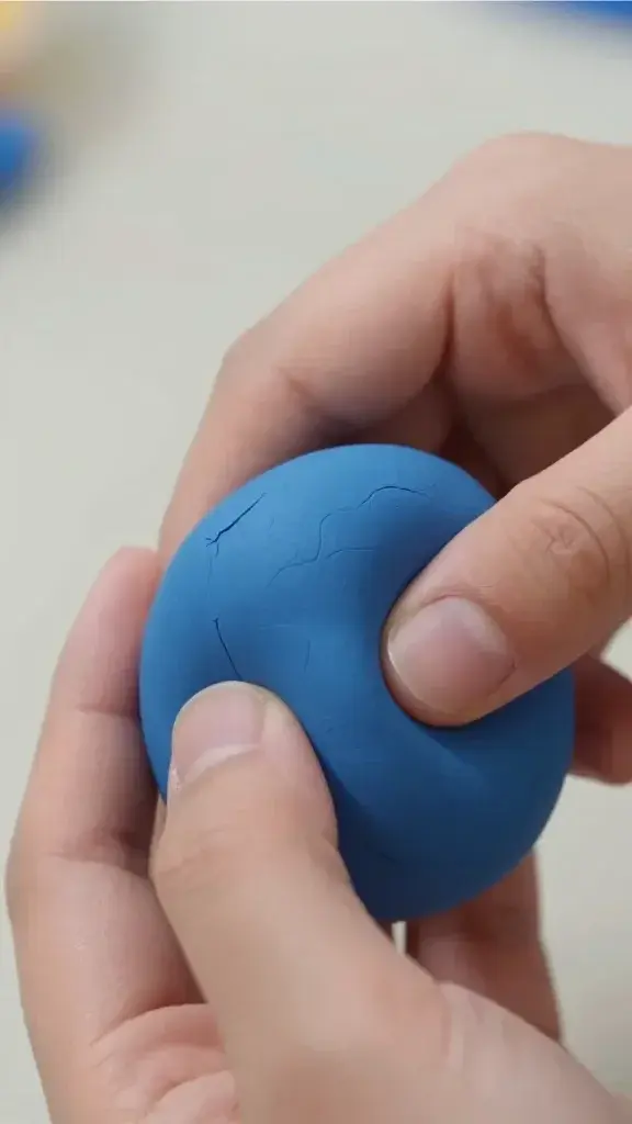 Closeup of hands kneading blue polymer clay